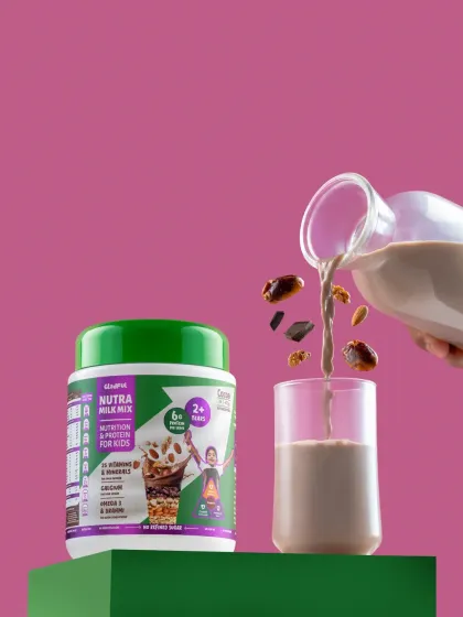 An action shot of a healthy drink being poured into a glass, with the product packaging clearly visible.