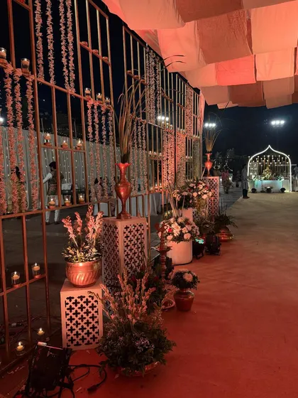 The side view of the candle-lit entrance walkway, showing the intricate jali walls and the warm, ambient lighting.
