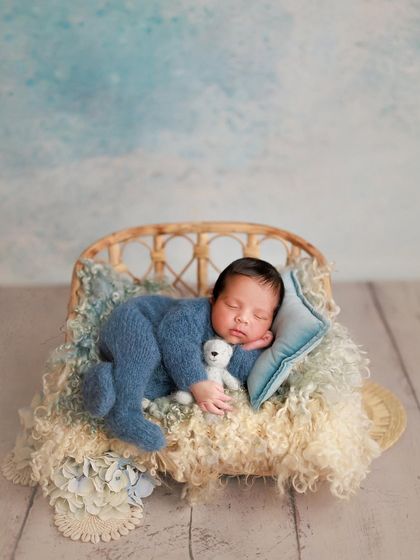 A symphony of blues. This little one is sleeping peacefully on a tiny bed with a soft blue pillow, creating a serene and dreamy cloud-like scene.