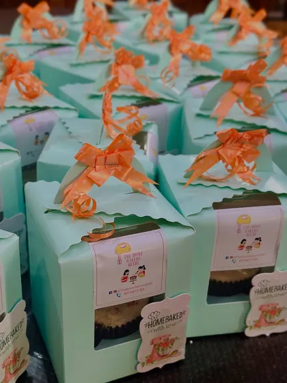 For larger events, we offer individual packaging. Here are the farewell cupcakes packed in single mint-green boxes with a window, tied with an orange ribbon. This makes them easy to hand out as party favors.