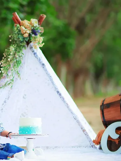 We create complete, themed setups for pre birthday photoshoots. This outdoor scene includes a decorated teepee, a cake stand, and props to make the celebration special.