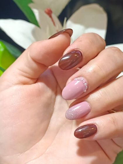 Perfect for the autumn-winter season, this gel nail design combines rich brown tones with soft pinks, accented with glitter and crystals.