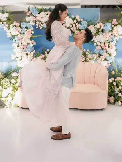 Yash and Sakshi share a dance at their engagement party. The backdrop of blue and pink florals against a sky-blue wall created a dreamy, pastel-perfect setting.