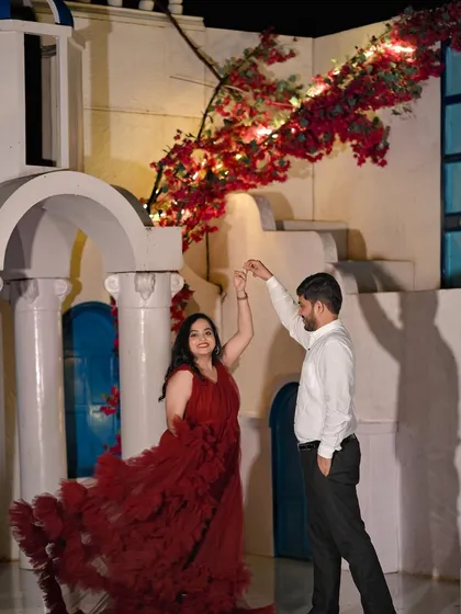 A couple dances in front of our Santorini-inspired set at night, with flowers and lights adding to the romantic Mediterranean feel.