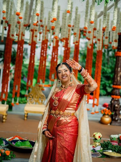 A happy, waving bride under a canopy of flowers, her joy and beauty on full display.
