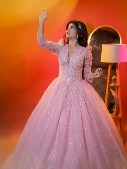 A fairytale princess look. The sparkling pink gown is paired with soft, romantic makeup and flowing curls.