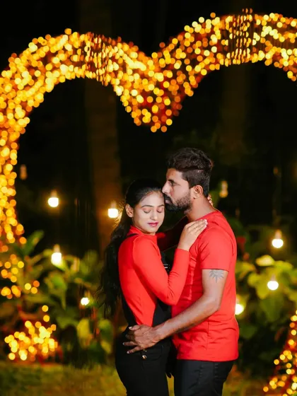 A tender and romantic embrace in front of the glowing heart prop.