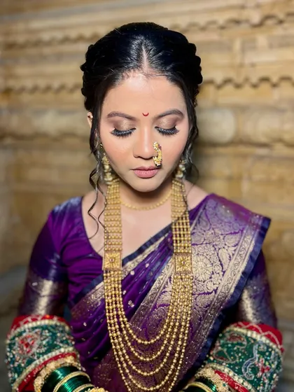 This shot with eyes closed highlights the soft, shimmery eyeshadow that complements her purple saree. It showcases the delicate details that go into creating a balanced and beautiful bridal look.