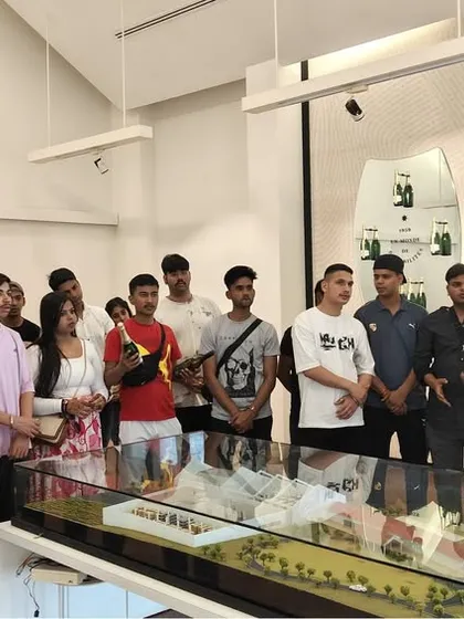 Students gather around a detailed model of the winery, learning about the architecture and operational flow of a large-scale beverage production facility. This provides a macro view of the industry.