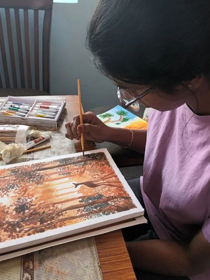 Here is my offline student Harshni, carefully adding details to her watercolour landscape. She is learning to layer colours to create depth and light.