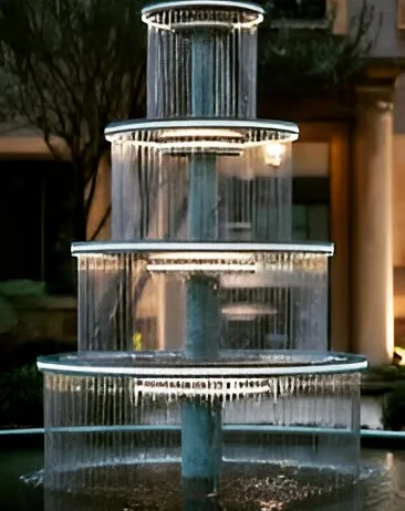 A multi-tiered, modern fountain with integrated lighting. Water flows in sheets from one level to the next, creating a mesmerizing effect, especially at night.