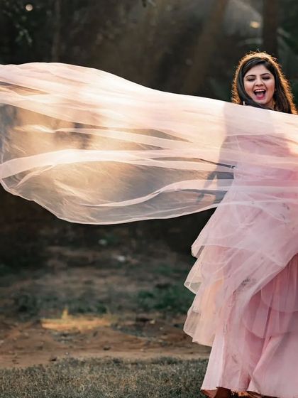 The soft peach color of this net trail gown gives it a romantic, sunset feel. The lightweight fabric is easy to work with and creates beautiful, airy shapes.