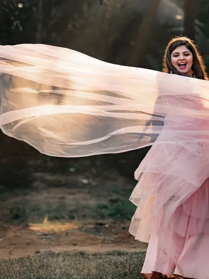 The soft peach color of this net trail gown gives it a romantic, sunset feel. The lightweight fabric is easy to work with and creates beautiful, airy shapes.