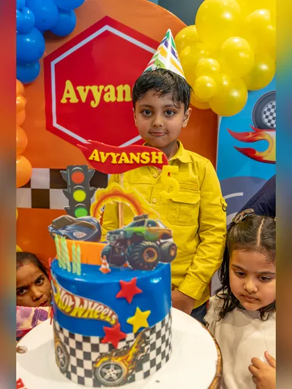 The birthday boy poses with his amazing Hot Wheels cake, ready to celebrate turning five.