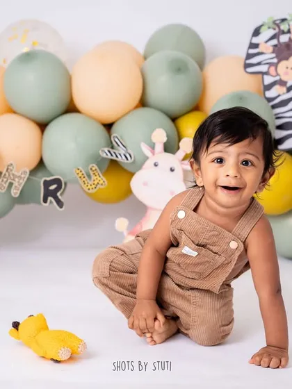 A jungle-themed cake smash is a perfect way to celebrate a "wild one." This little cub is having a great time exploring his setup before digging into the cake.