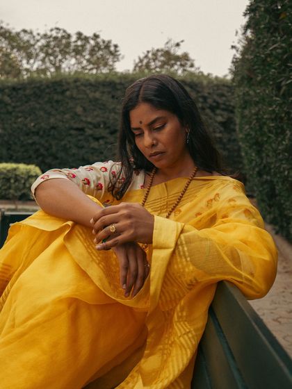 A quiet, contemplative moment on the bench, showcasing the soft drape of the saree. I use different poses and moods to bring out the subject's personality during a portrait session.