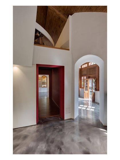 The circulation path within the museum is designed as a journey through history, with arched doorways framing views into different galleries. The polished concrete floor reflects light, unifying the sequence of spaces.