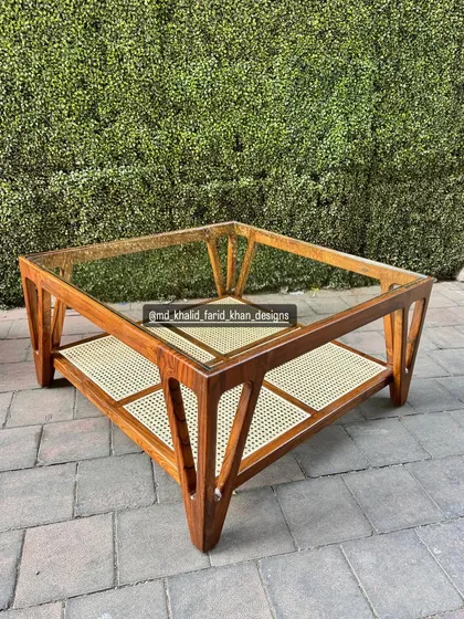 This view highlights the angular leg design of the glass and cane coffee table.
