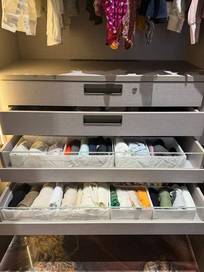 Pull-out drawers with glass sides and internal dividers keep folded clothes perfectly contained and visible from the side.