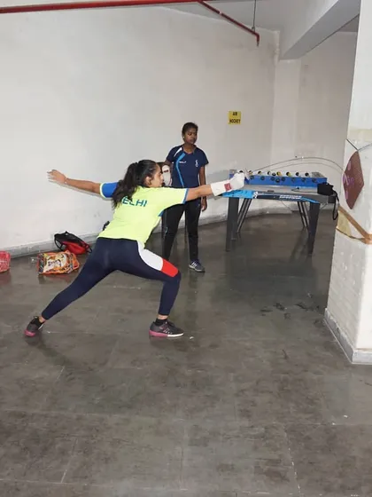 A student focuses intently on the target as she practices her lunge. Mental focus is just as important as physical skill in fencing.