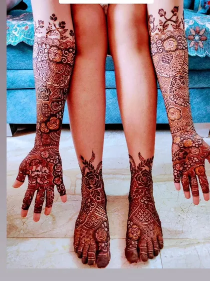 A full bridal look with matching designs on hands and feet, featuring delicate vines climbing up the legs.
