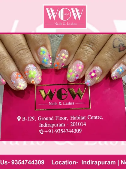 A fun and colorful design on short, square extensions. This look features a glittery base with multi-colored floral polka dots, creating a playful and happy vibe.