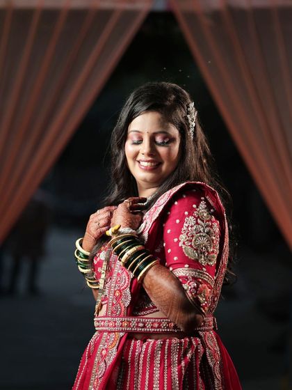 A candid moment of bridal joy. This image captures the beautiful details of the red lehenga and the happiness of wearing your dream outfit.