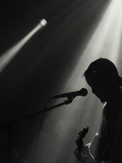 A silhouette of my bandmate, lost in the music under the spotlight.