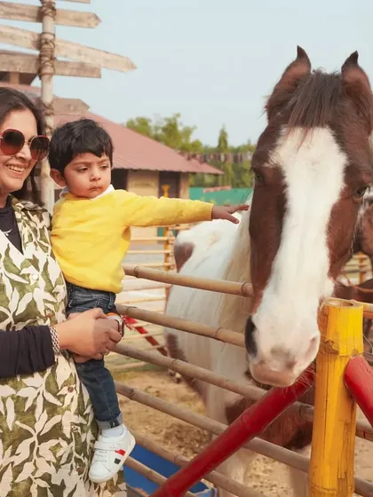 Our event photography goes beyond the party hall. Here, we captured a tender moment between a mother and her son as he gently pets a horse at his farm-themed birthday party, creating a memory of a unique experience.