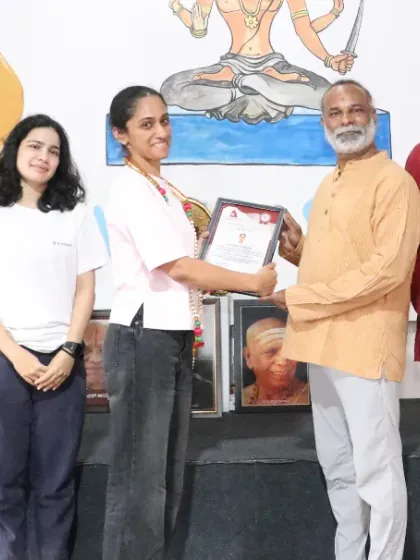 A graduate of our 200-hour TTC receives her certificate, marking the successful completion of her training.