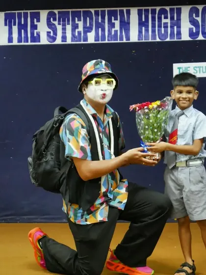 A young boy presents a bouquet of flowers to the 'Silent Storyteller'. This gesture of gratitude shows the deep impact these special sessions have on the children.