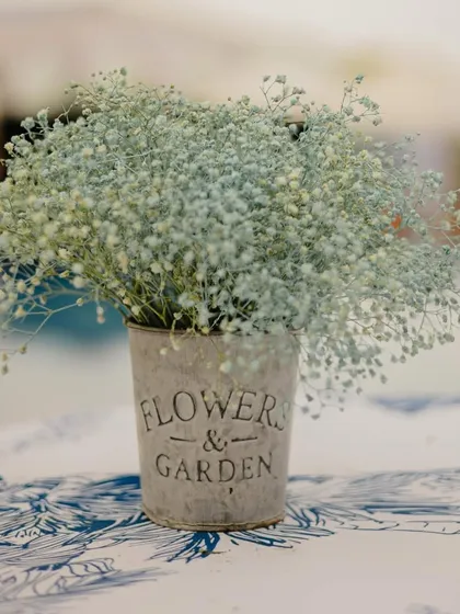 A delicate baby's breath arrangement in a rustic tin, part of a 'Carnival of Love' theme with a soft, aesthetic vibe.