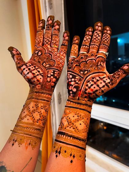 This design is perfect for a bridesmaid who wants an intricate look. It features beautiful bands and detailed patterns that extend up the arm, complementing the bride's henna perfectly.