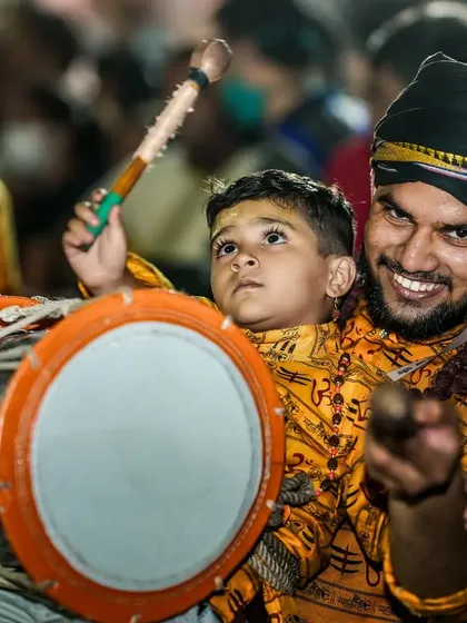 A heartwarming moment of tradition being passed down, as a father teaches his young son how to play the dhol.
