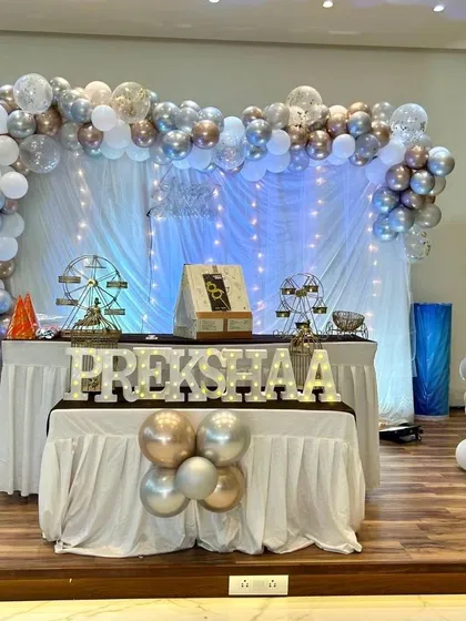 A sophisticated silver, gold, and white theme for Prekshaa's 8th birthday. The fairy lights and elegant balloon arch create a magical setting for an older child's celebration.