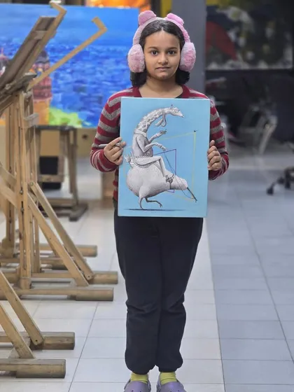 A young student proudly holds her finished whimsical artwork. This piece is a wonderful mix of ballpoint pen drawing and a painted background.