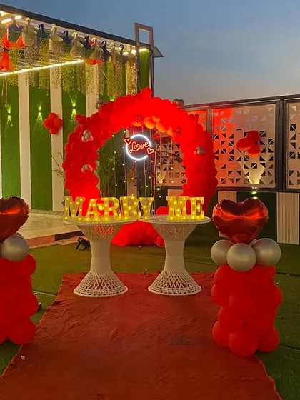 The proposal decoration looks just as stunning as the sun sets. The glowing "MARRY ME" letters and the neon "Love" sign create a magical ambiance for an evening proposal.