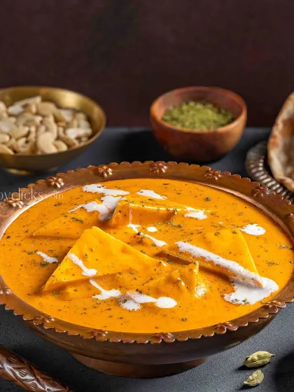 Paneer Pasanda in a creamy, orange gravy. This shot for The Mughal House highlights the smooth texture of the curry and the soft paneer, making it an appealing vegetarian option.