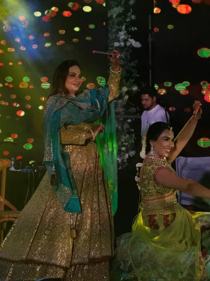 A close-up of the energetic dandiya performance. The colorful outfits and smiling faces perfectly capture the joy of a daytime wedding celebration.