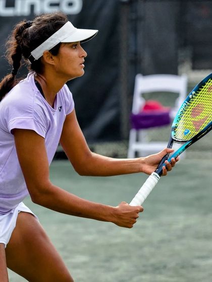 Sahaja's focused stance as she awaits a serve, ready to unleash a powerful return.
