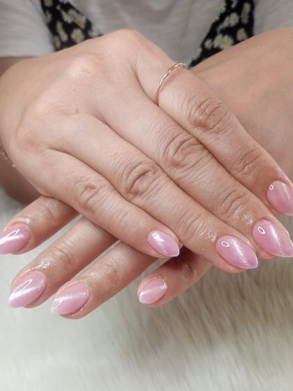 A classic pink cat eye manicure on almond-shaped nails.