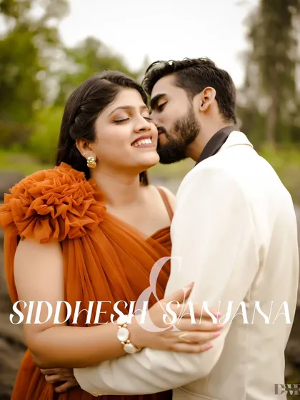 A tender kiss that speaks of deep affection. The bride's beautiful orange dress stands out against the natural backdrop in this romantic pre-wedding portrait.