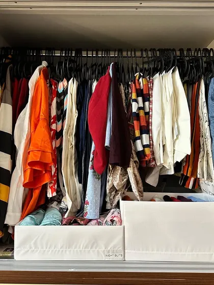 Here, we've placed bins directly on the shelf under hanging clothes to store folded items. This simple solution prevents piles from toppling over.