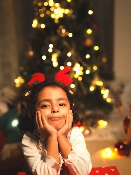 The many faces of a child waiting for Christmas. This little girl's expressions are just too cute in this warm, holiday-themed shot.