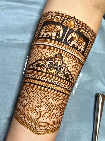 A detailed arm band featuring a procession of elephants and a pair of swans. The intricate patterns and clean lines create a very regal and elegant look.