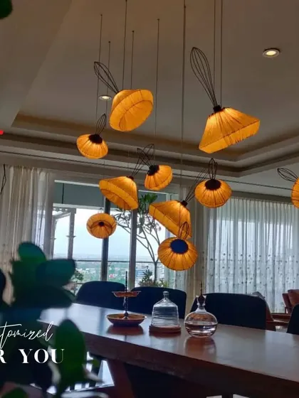 These custom pendant lights act as a sculptural installation over the dining table, adding a touch of artistry and warm, ambient light.