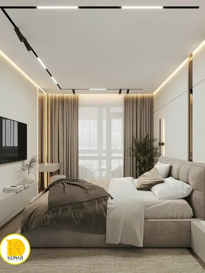 This wide view of the bedroom shows the bed, TV unit, and the large window with elegant curtains.
