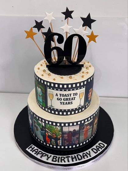 A cinematic celebration for a dad's 60th. This two-tiered cake is designed like a film reel, featuring edible photo strips of cherished memories.