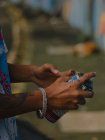 My hands, covered in paint, holding a spray can during the Rohit Sharma mural project. This is the reality of a graffiti artist's work; you get your hands dirty to create something clean.