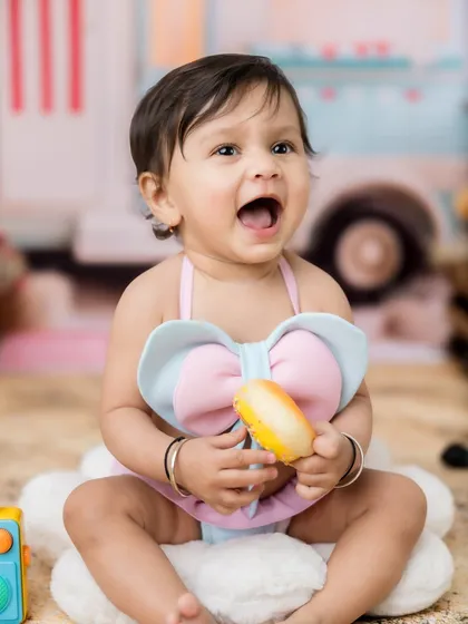 A big, happy expression from this little girl in her beach-themed setup.
